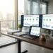 Office desk with multiple screens showing data dashboards